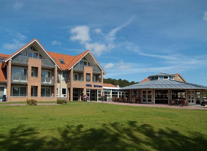 Luxurioeses Zimmer im Hotel Bornholm, West-Terschelling, mit bequemem Bett und Arbeitsbereich.