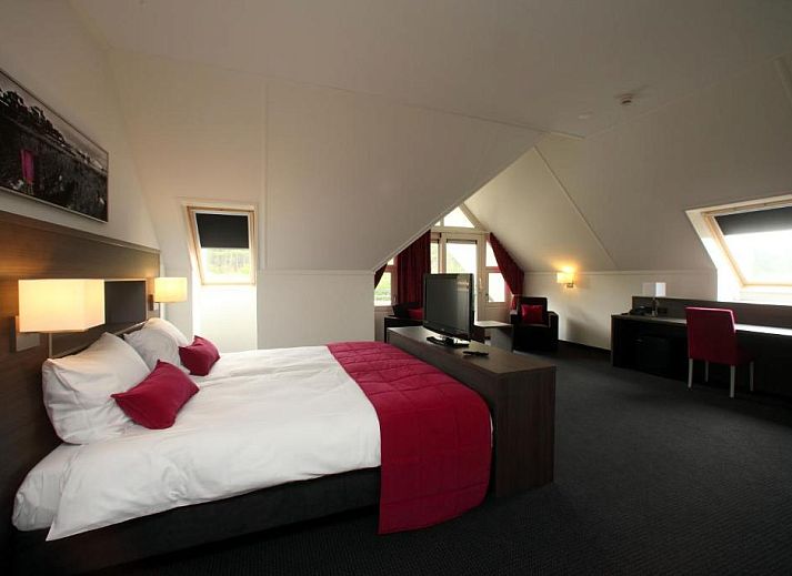 Luxurioeses Zimmer im Hotel Bornholm, West-Terschelling, mit bequemem Bett und Arbeitsbereich.