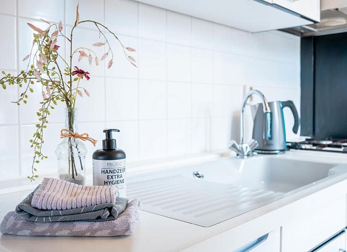 Gemuetliches Wohnzimmer im Hotel Pension de Harmonie, Edam, mit Treppe und Essbereich.