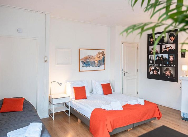 Gemuetliches Wohnzimmer im Hotel Pension de Harmonie, Edam, mit Treppe und Essbereich.