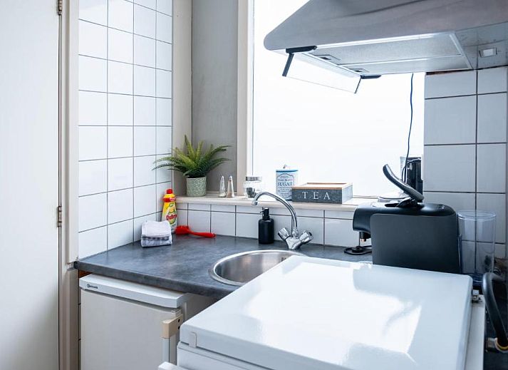 Gemuetliches Wohnzimmer im Hotel Pension de Harmonie, Edam, mit Treppe und Essbereich.