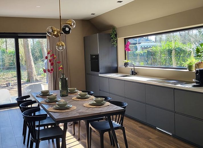 Relax on the porch of Huisje in Appelscha, a vacation home in the Frisian woods, Friesland, with a view of nature.