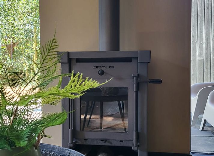 Relax on the porch of Huisje in Appelscha, a vacation home in the Frisian woods, Friesland, with a view of nature.