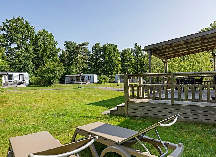 Ruim terras van Mobil home de Libelle in de Friese bossen, ideaal voor buitenmaaltijden.