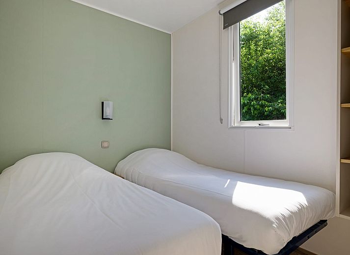 Ruim terras van Mobil home de Libelle in de Friese bossen, ideaal voor buitenmaaltijden.