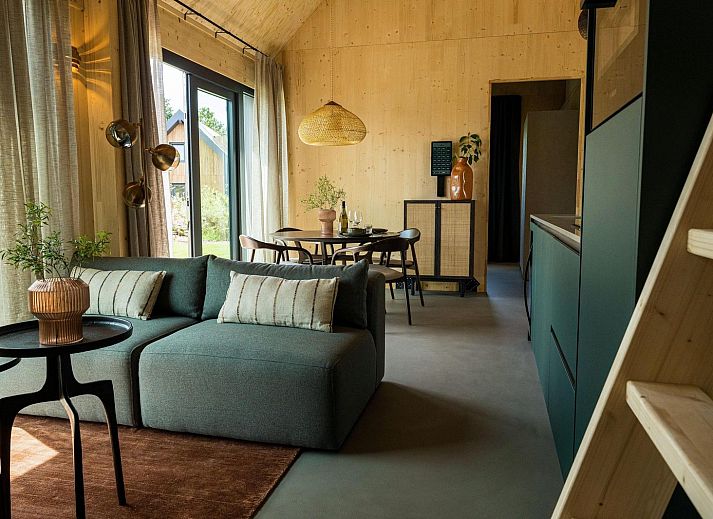 Lichte en moderne woonkamer in Unbrick One vakantiehuis, gelegen in de Friese bossen.