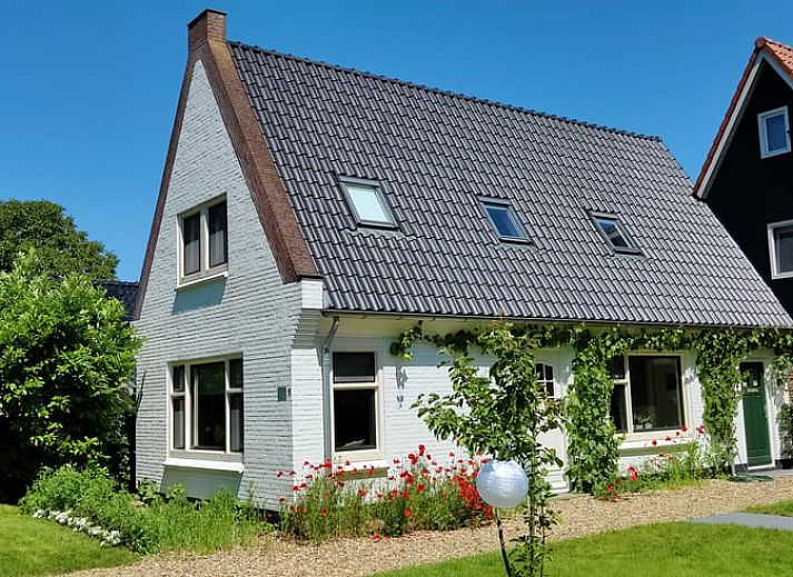 Vakantiehuisje in Ruigahuizen omringd door kleurrijke bloemen in de Friese bossen, Friesland.
