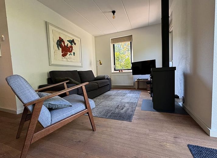 Vorderseite des Ferienhauses in Sondel mit Sonnenschirm in den friesischen Waeldern von Friesland.