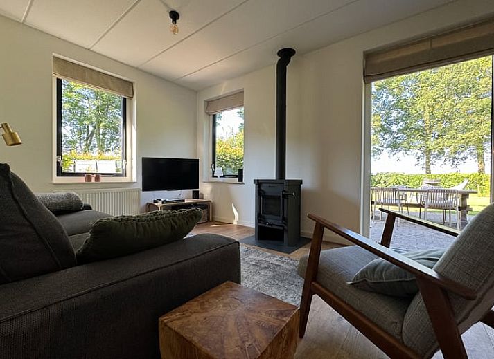 Vorderseite des Ferienhauses in Sondel mit Sonnenschirm in den friesischen Waeldern von Friesland.