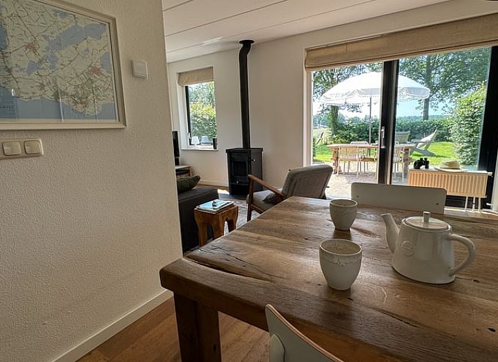 Vorderseite des Ferienhauses in Sondel mit Sonnenschirm in den friesischen Waeldern von Friesland.