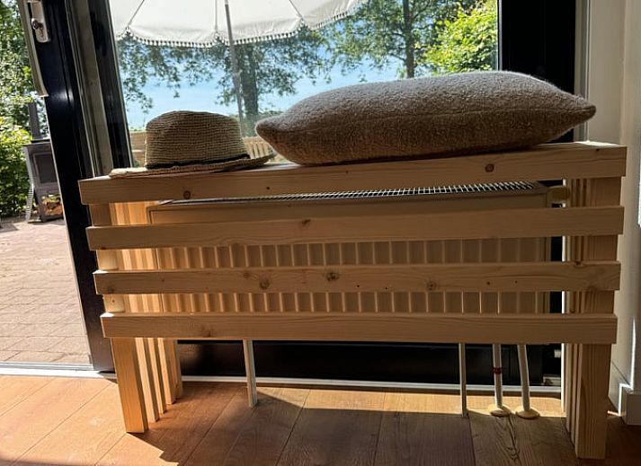 Vorderseite des Ferienhauses in Sondel mit Sonnenschirm in den friesischen Waeldern von Friesland.