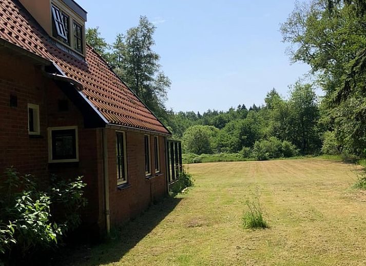 Comfortabele zithoek met uitzicht op tuin in Huisje in Haule, vakantiehuis in Friese bossen.