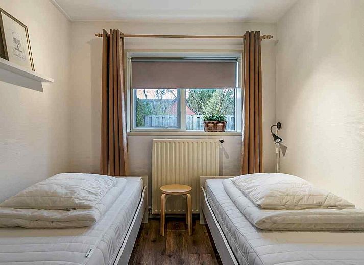 FR163 vakantiehuis in Bakkeveen, Friesland met moderne entree en omringd door groene hagen.