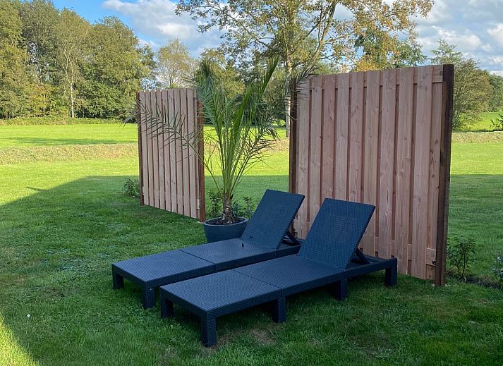 Zonnige tuin met ligstoelen bij vakantiehuis FR439 in Noordwolde, Friesland.