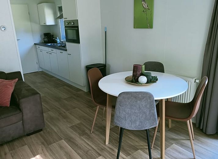 Veranda des Ferienhauses in Oosterwolde, in den friesischen Waeldern von Friesland, mit bequemen Sitzgelegenheiten und Blick auf die Natur.