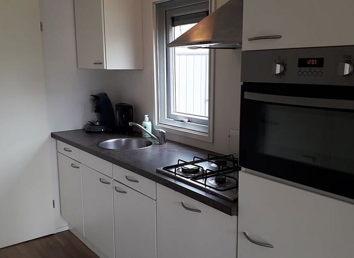 Veranda des Ferienhauses in Oosterwolde, in den friesischen Waeldern von Friesland, mit bequemen Sitzgelegenheiten und Blick auf die Natur.