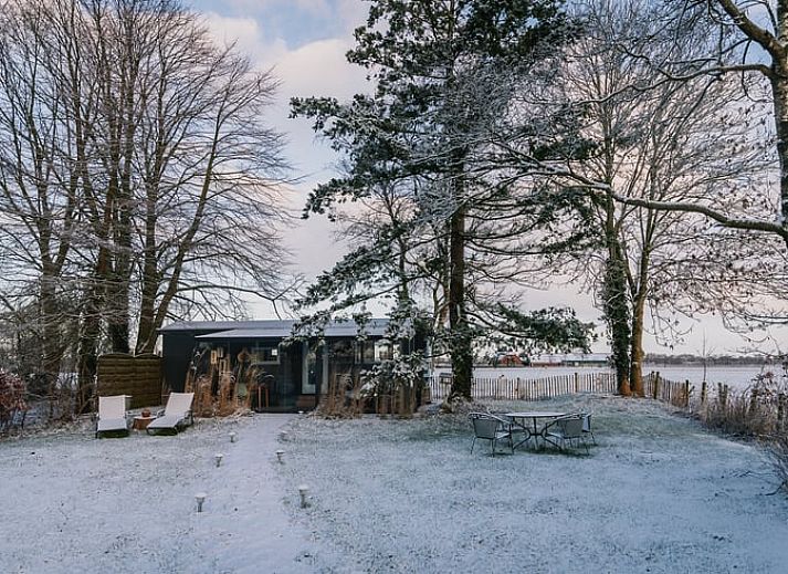 Gemuetliches Wohnzimmer des Ferienhauses in Oosterwolde, mit Blick auf die friesische Landschaft.