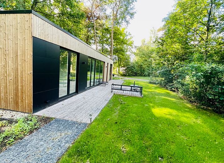 Moderne Holzfassade des Ferienhauses in Oosterwolde, umgeben von friesischen Waeldern in Friesland.