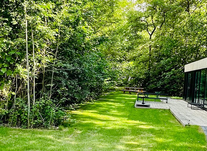 Moderne Holzfassade des Ferienhauses in Oosterwolde, umgeben von friesischen Waeldern in Friesland.