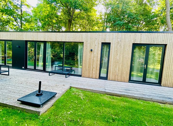 Moderne Holzfassade des Ferienhauses in Oosterwolde, umgeben von friesischen Waeldern in Friesland.