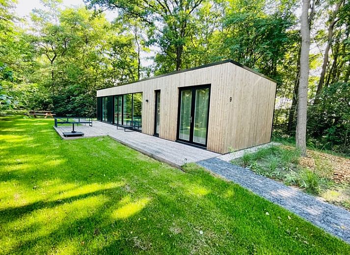 Moderne Holzfassade des Ferienhauses in Oosterwolde, umgeben von friesischen Waeldern in Friesland.