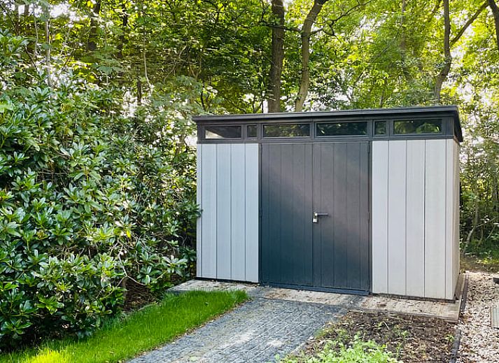 Geraeumige Terrasse am Ferienhaus in Oosterwolde, umgeben von gruener Natur in Friesland.