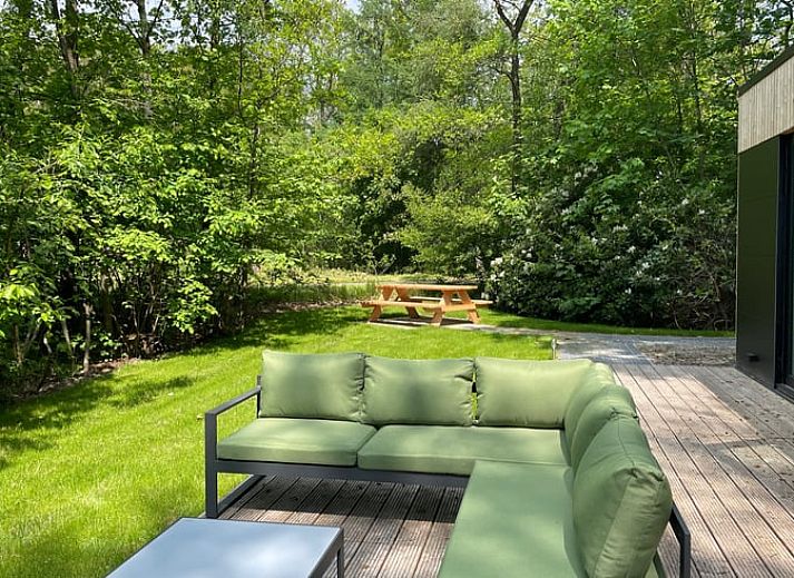 Geraeumige Terrasse am Ferienhaus in Oosterwolde, umgeben von gruener Natur in Friesland.