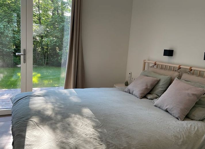 Gruener Garten des Ferienhauses in Oosterwolde, ideal zum Entspannen in den friesischen Waeldern.