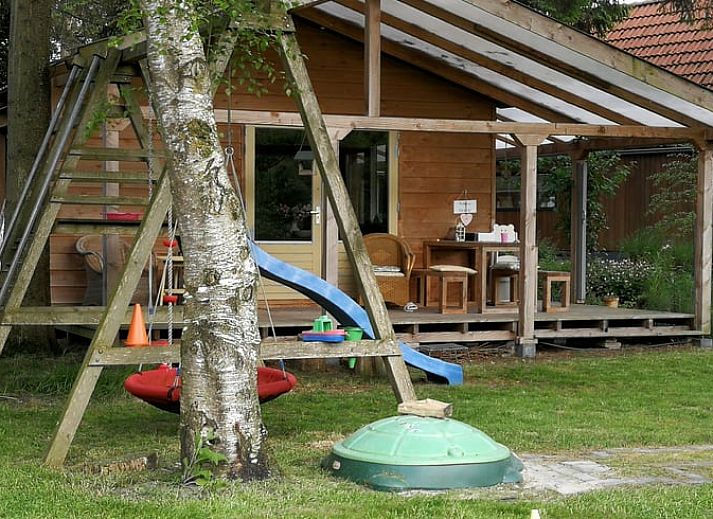 Terras bij Vakantiehuisje in Haulerwijk met uitzicht op vijver, gelegen in de Friese bossen van Friesland.