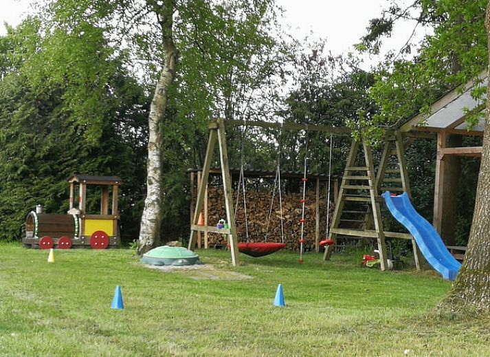 Terras bij Vakantiehuisje in Haulerwijk met uitzicht op vijver, gelegen in de Friese bossen van Friesland.
