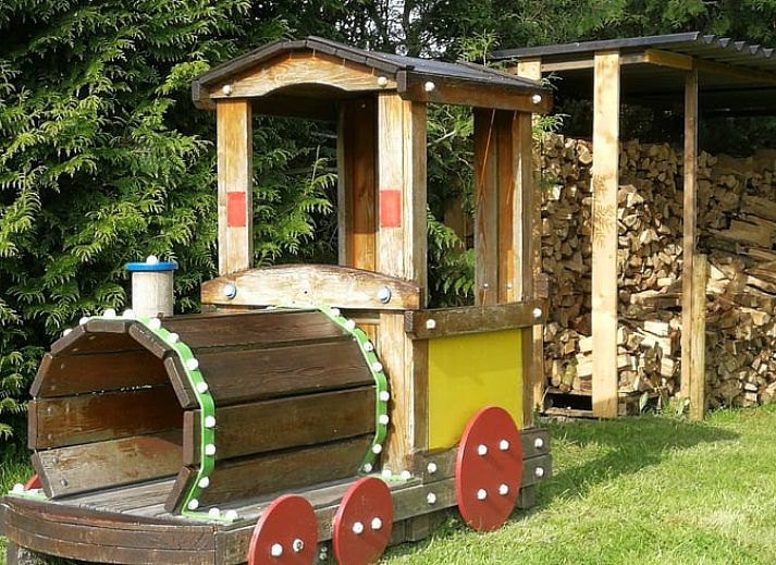 Terras bij Vakantiehuisje in Haulerwijk met uitzicht op vijver, gelegen in de Friese bossen van Friesland.