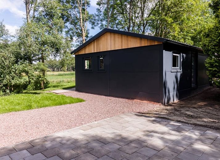 Das Ferienhaus in Ravenswoud, ein charmantes Ferienhaus in den friesischen Waeldern von Friesland, bietet rustikalen Charme und eine grosszuegige Terrasse mit Blick auf die Natur.