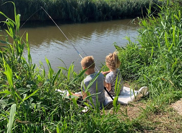 Cozy living room with dining area in vacation home at Recreatiebedrijf de Blikvaart, Sint Annaparochie, perfect for families in Friesland.