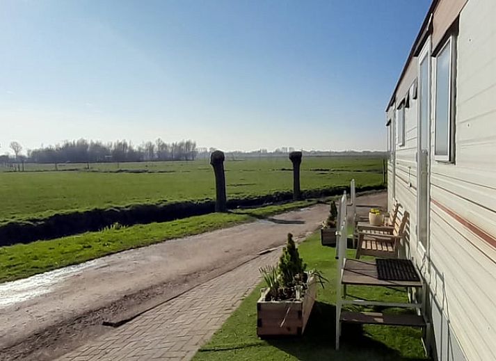 Geniet van het uitzicht op de groene velden vanaf het terras van Vakantiehuisje in Sneek, Friesland.