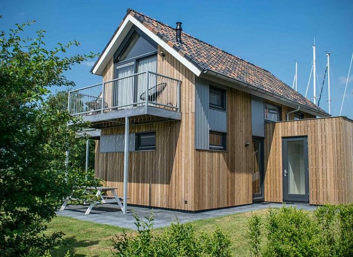 Huisje in Stavoren, een charmant vakantiehuis in Friesland met een moderne houten gevel en groene tuin.