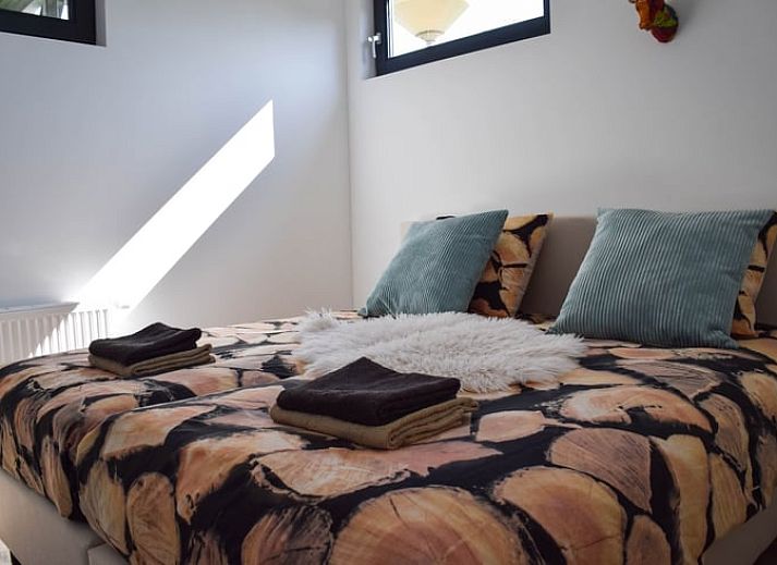 Keuken van Huisje in Stavoren, Stavoren, met feloranje kasten en moderne apparatuur in een lichte ruimte.