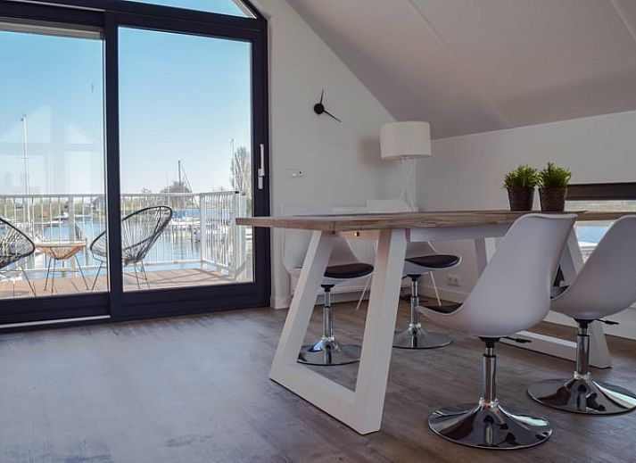 Keuken van Huisje in Stavoren, Stavoren, met feloranje kasten en moderne apparatuur in een lichte ruimte.