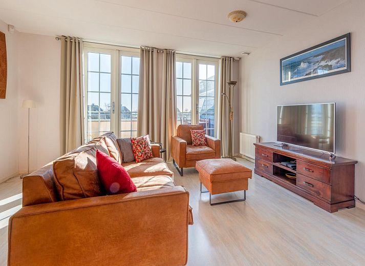 Luchtfoto van Schippershuis Stavoren, een vakantiehuis aan het water in Friesland, met aangemeerde zeilboot en rieten daken.