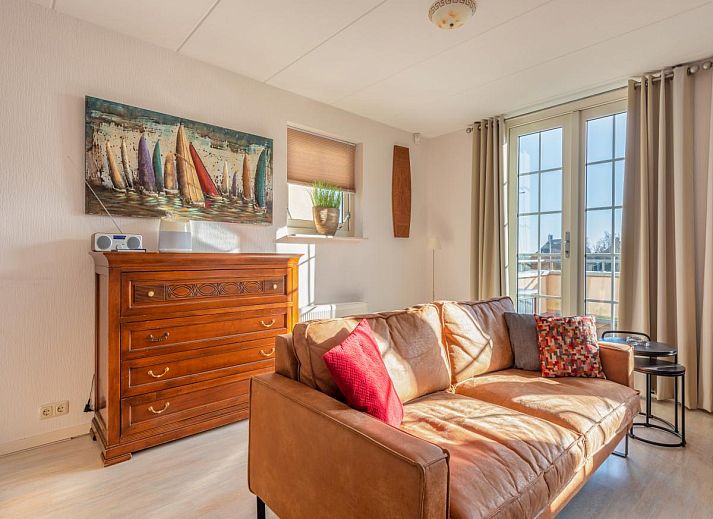 Luchtfoto van Schippershuis Stavoren, een vakantiehuis aan het water in Friesland, met aangemeerde zeilboot en rieten daken.