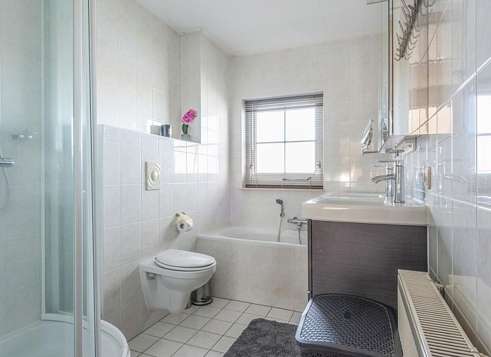 Stijlvolle binnenruimte van Schippershuis Stavoren, een vakantiehuis in Friesland, met kunst aan de muur en sfeervolle inrichting.