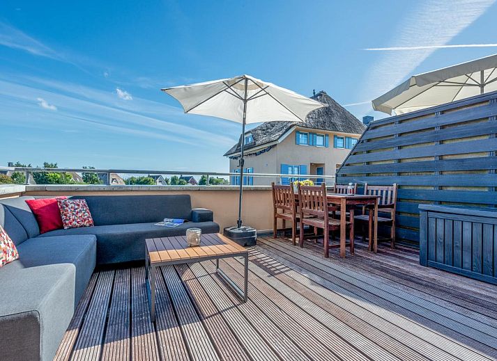 Stijlvolle binnenruimte van Schippershuis Stavoren, een vakantiehuis in Friesland, met kunst aan de muur en sfeervolle inrichting.