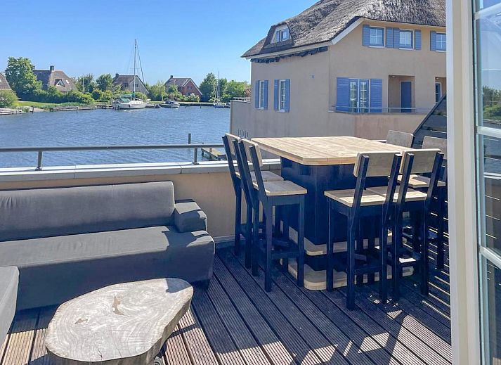 Stijlvolle binnenruimte van Schippershuis Stavoren, een vakantiehuis in Friesland, met kunst aan de muur en sfeervolle inrichting.