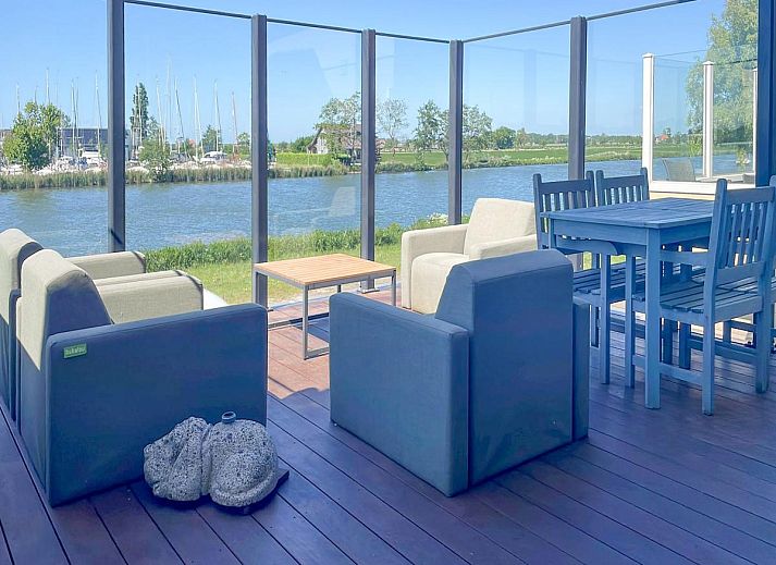 Stijlvolle binnenruimte van Schippershuis Stavoren, een vakantiehuis in Friesland, met kunst aan de muur en sfeervolle inrichting.