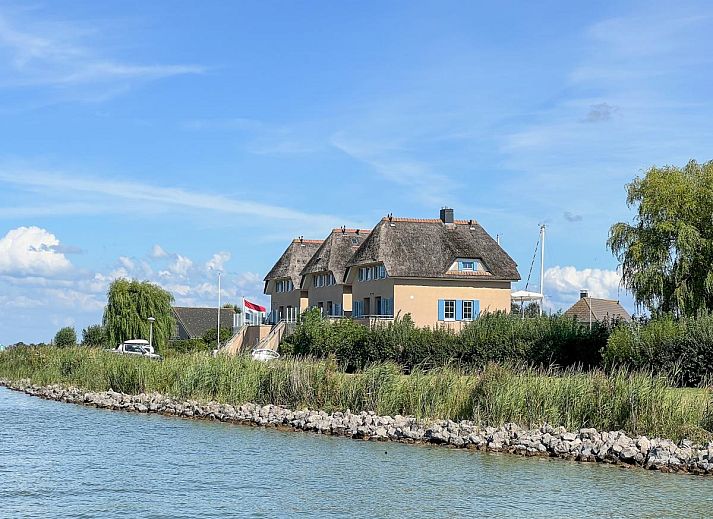 Eet- en leefruimte in Schippershuis Stavoren, vakantiehuis in Friesland, met houten meubels en moderne keukenfaciliteiten.