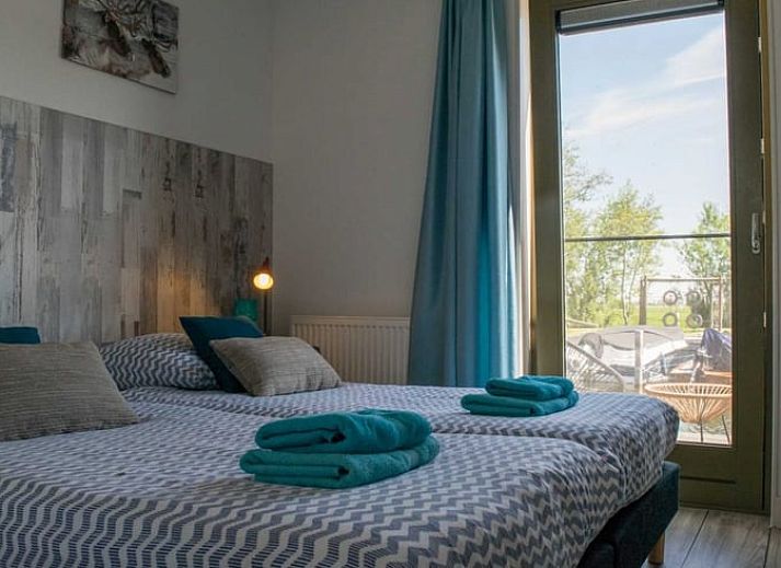 Vakantiehuis in Stavoren met houten gevel aan het water, gelegen in de Friese elfsteden, Friesland.