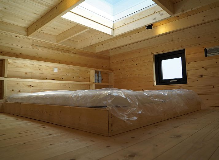 Interior of Chalet in Hindeloopen, Friesland, with wooden interior and stairs to sleeping loft.