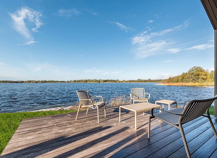 Modern seating area in glamping lodge 4-6B1 in Oudehaske, Friesland, featuring a flat-screen TV.