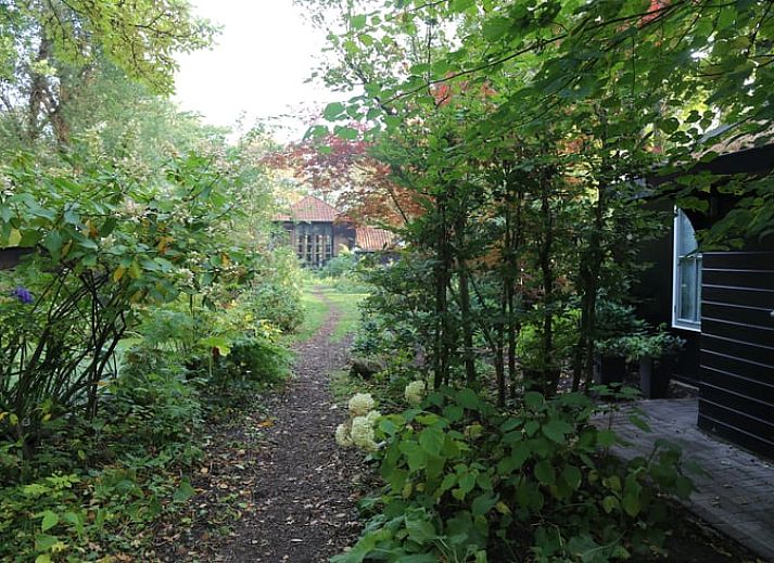 Moderne Sitzecke im Ferienhaus in Makkinga mit Blick auf die gruene Umgebung von Friesland.