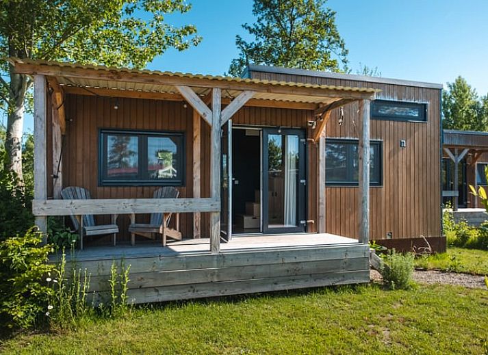 Houten exterieur van Vakantiehuis in Scherpenzeel, omringd door groen in Friesland.