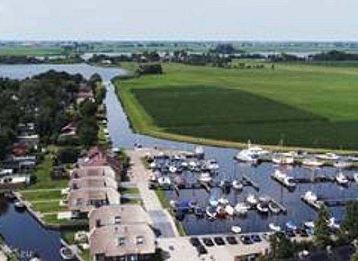 Rustgevend uitzicht vanaf Vakantiehuis in Idskenhuizen op het Friese platteland, met serene waterwegen en landelijke schoonheid.